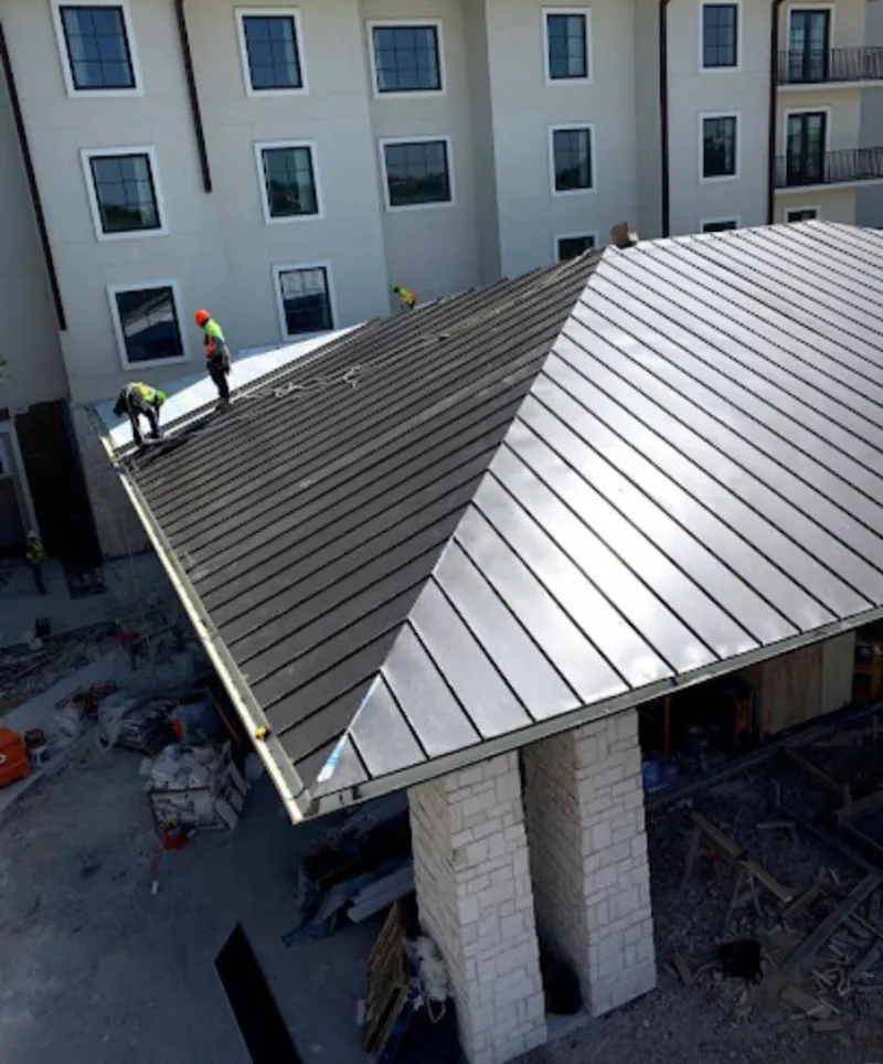 Crew installing standing seam metal roof panels on a commercial project in Wesley Chapel